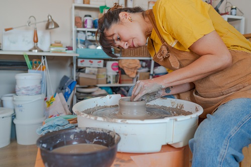 Woman working on pottery wheel