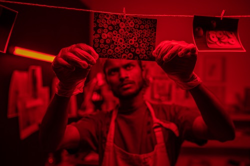 Man processing photos in dark room