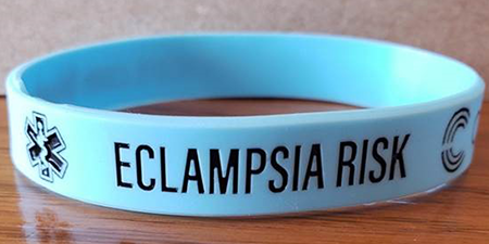 A blue rubber wristband with Eclampsia Risk printed on it.