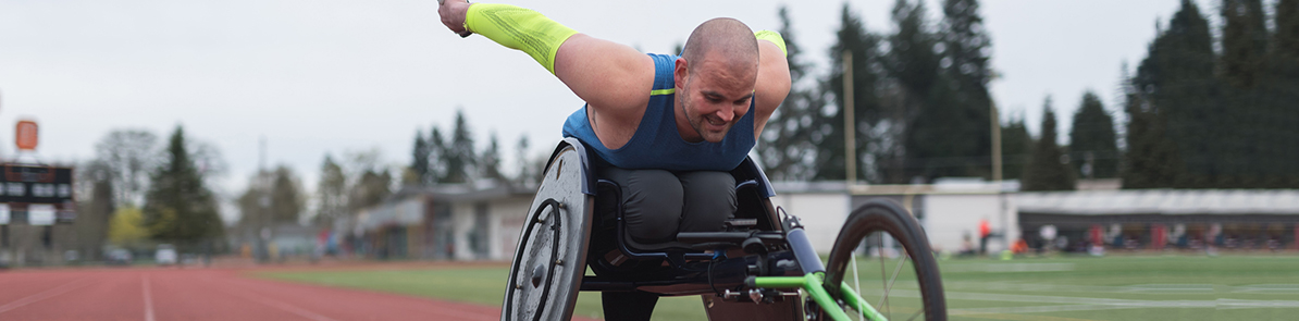 Athlete in wheel chair racing on a track.