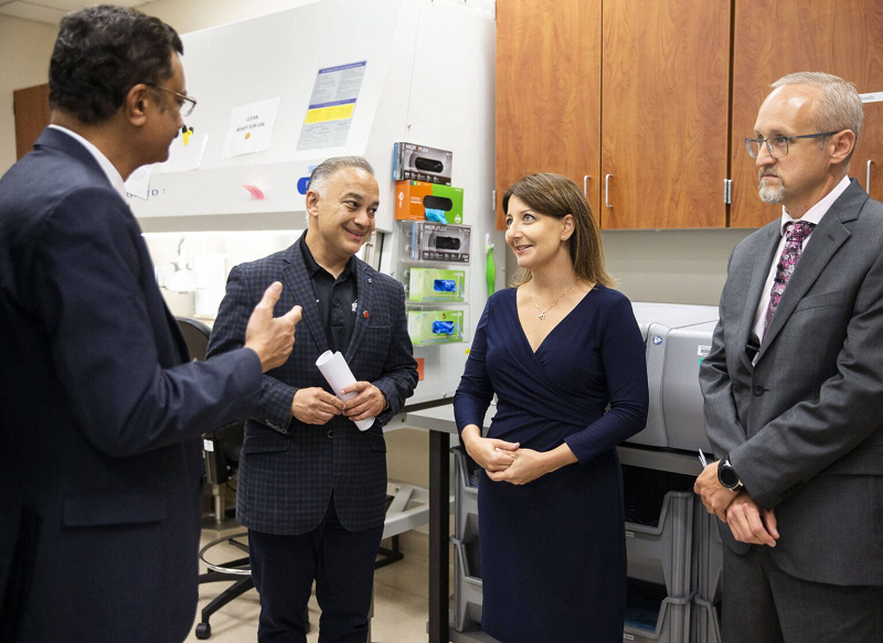 Dr. Shah talking with group of people at Public Health Lab.