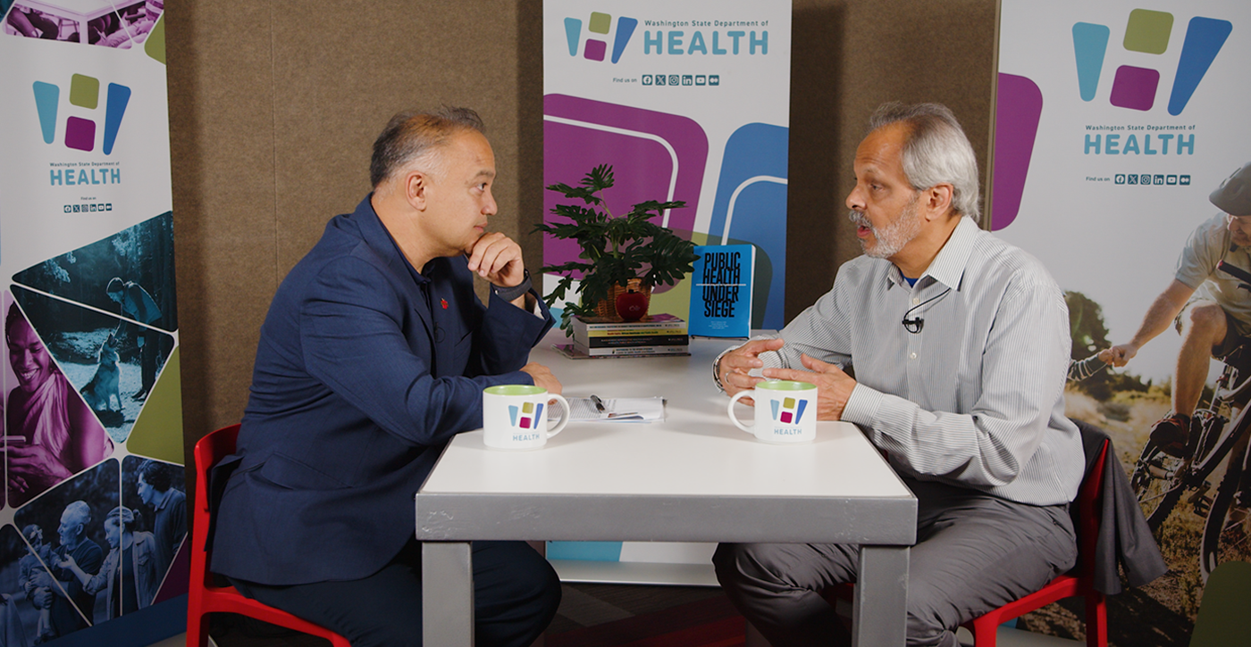 Dr. Umair Shah and Eduardo Sanchez talking at a table.