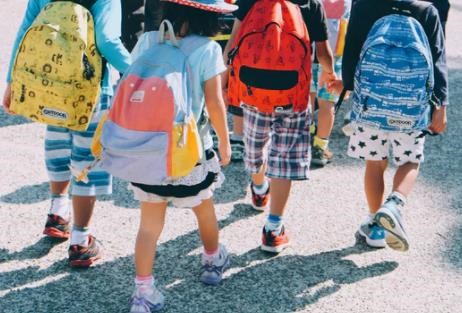 School children wearing backpacks