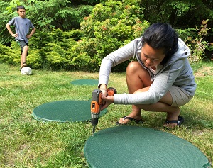 Woman securing a septic tank lid.