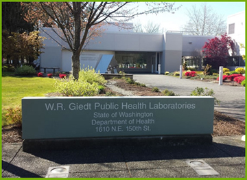 Public Health Laboratories building with green grass and cement sign with address in foreground