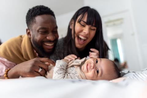 A man and woman smile at their baby