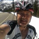 Steve Hulsman self-portrait wearing a bicycle helmet on a mountain road.