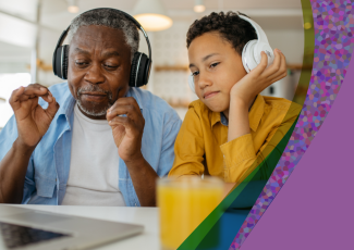 Grandfather and grandson listen to music on headphones.